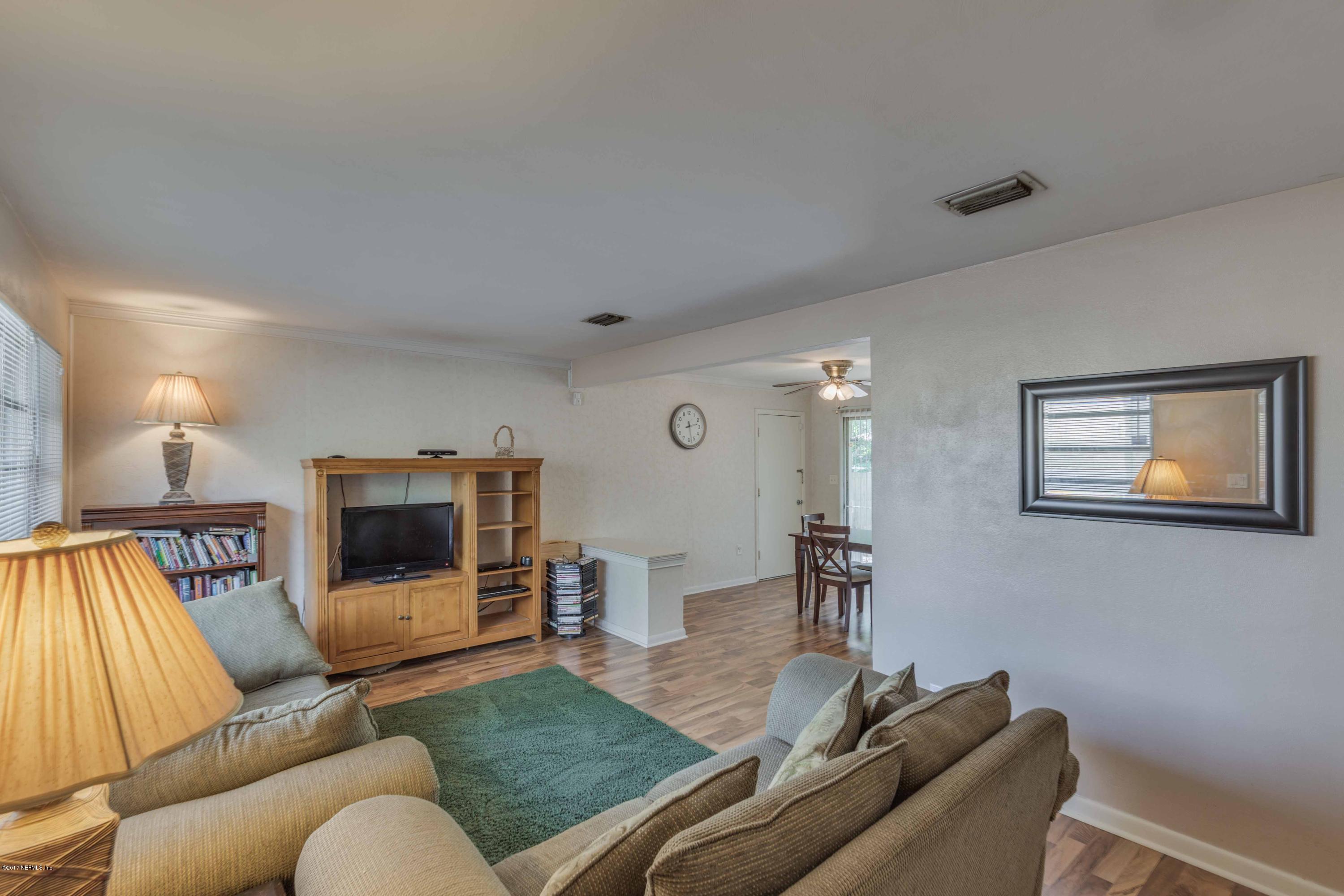 4020 Rogero Road Jacksonville, FL 32277 - Photo 4 of 23 a living room with furniture and a flat screen tv
