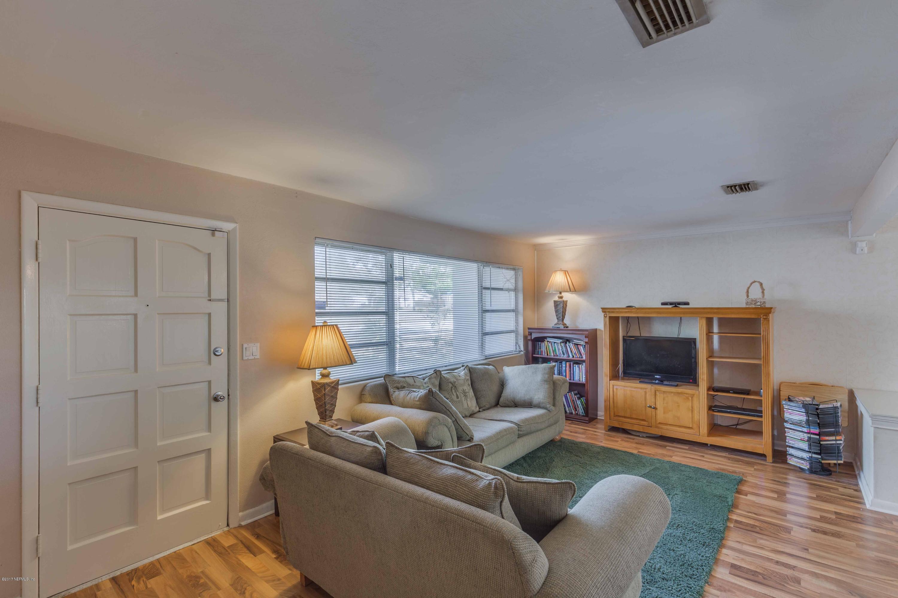 4020 Rogero Road Jacksonville, FL 32277 - Photo 5 of 23 a living room with furniture and a flat screen tv