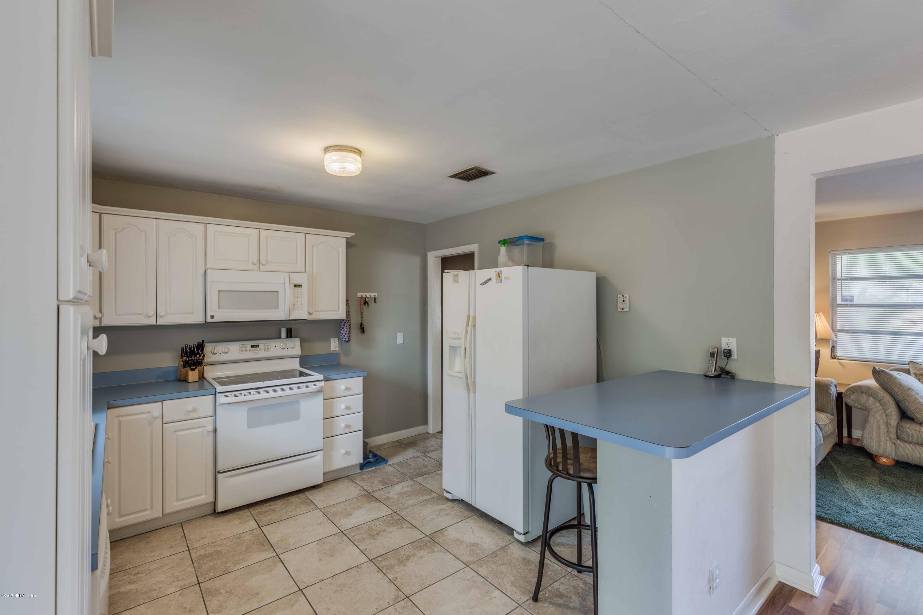 4020 Rogero Road Jacksonville, FL 32277 - Photo 10 of 23 a kitchen with a stove a sink and a refrigerator