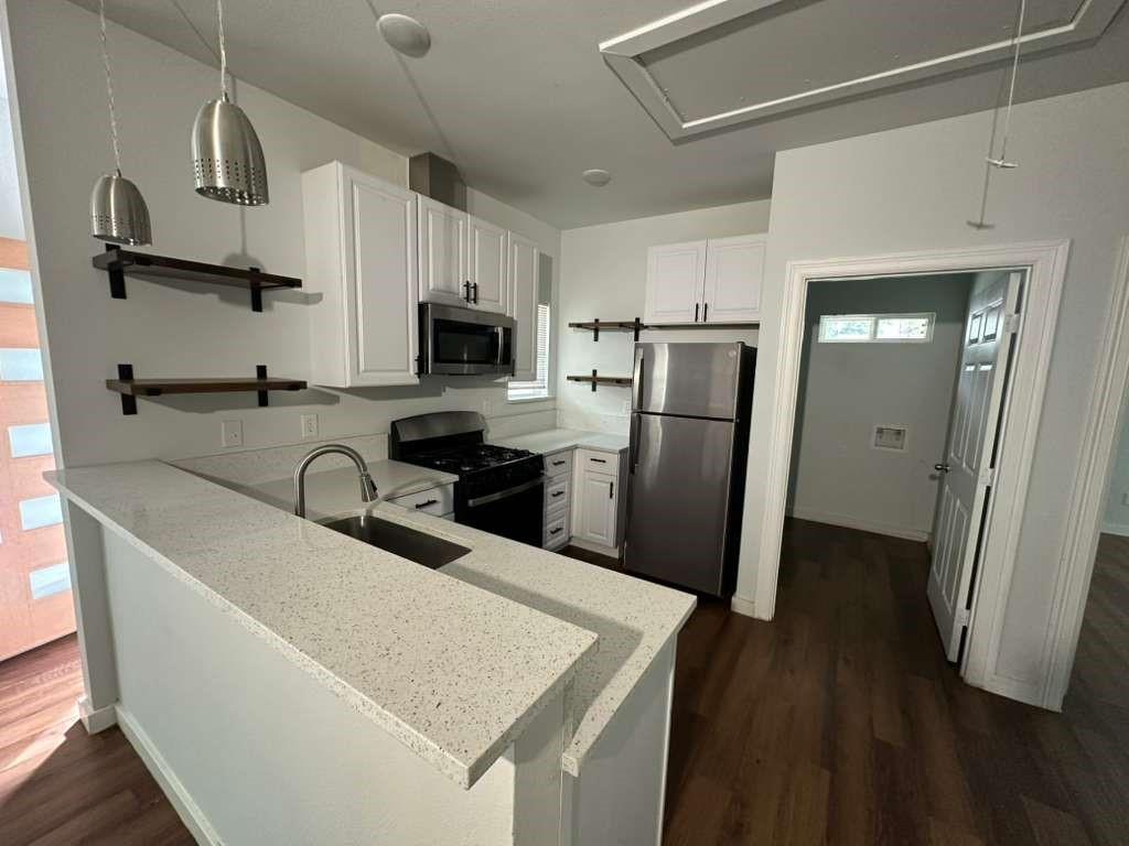 1307 West 33rd Street Tyler, TX 75702 - Photo 3 of 11 a kitchen with stainless steel appliances granite countertop a refrigerator a stove top oven a sink and dishwasher