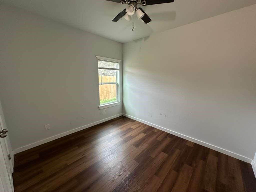 1307 West 33rd Street Tyler, TX 75702 - Photo 8 of 11 wooden floor in an empty room with a window