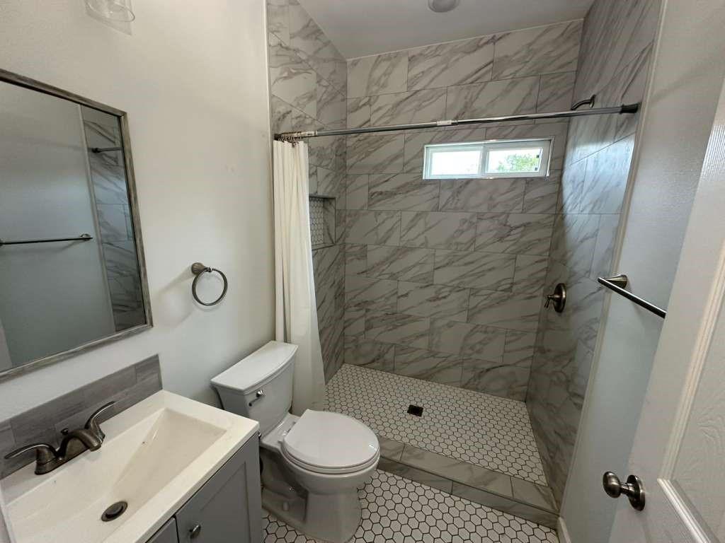 1307 West 33rd Street Tyler, TX 75702 - Photo 9 of 11 a bathroom with a sink toilet and shower