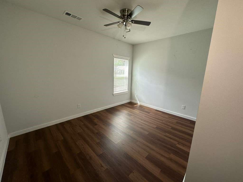 1307 West 33rd Street Tyler, TX 75702 - Photo 10 of 11 an empty room with wooden floor and windows