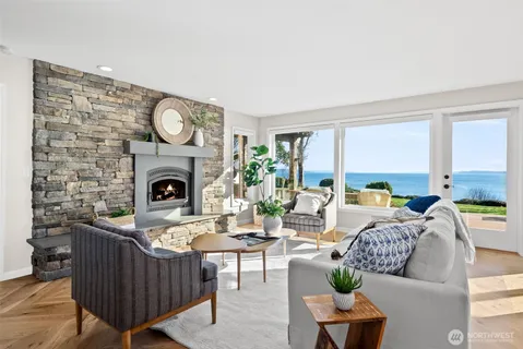 a living room with furniture a fireplace and a large window