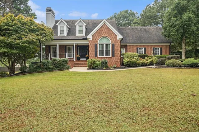 a front view of a house with yard and outdoor seating