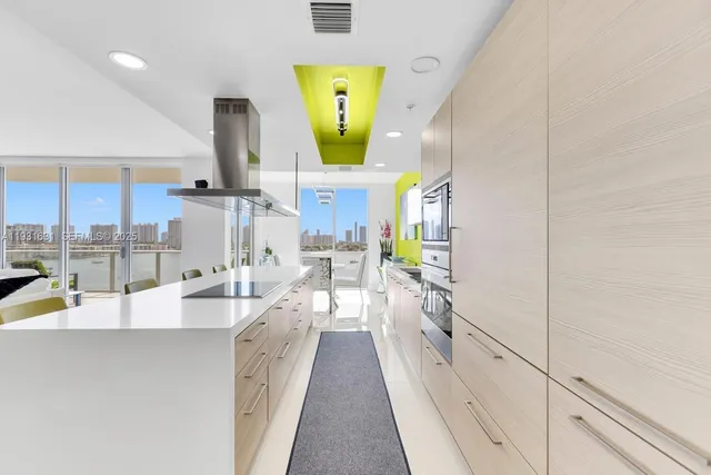 a large kitchen with a sink and stainless steel appliances