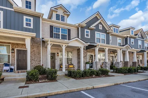 front view of a brick house with a yard