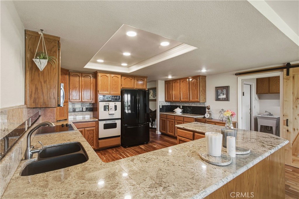 3856 North Gardner Avenue Merced, CA 95340 - Photo 12 of 59 a kitchen with stainless steel appliances granite countertop a sink stove and refrigerator