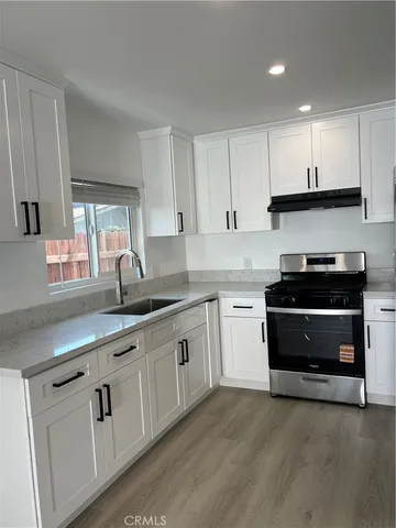 a kitchen with granite countertop white cabinets and appliances