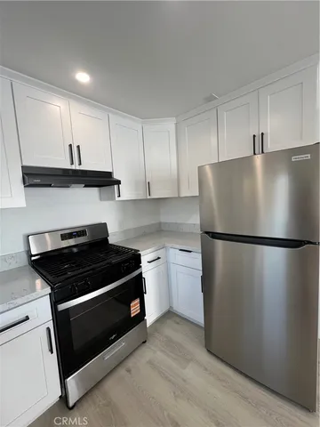 a kitchen with a refrigerator and a stove top oven