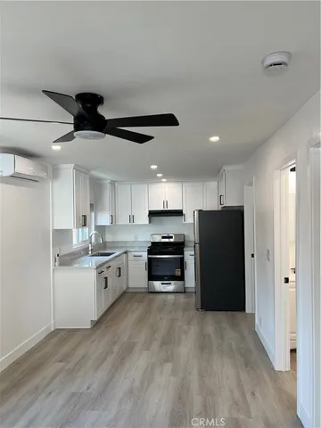 a kitchen with a refrigerator a stove top oven a sink and cabinets