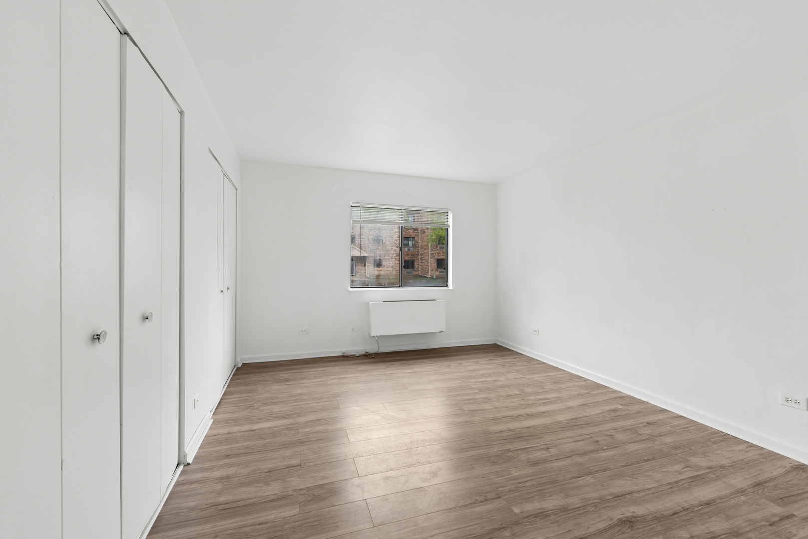 2213 West Nichols Road, Unit B Arlington Heights, IL 60004 - Photo 11 of 23 a view of an empty room with wooden floor and a window