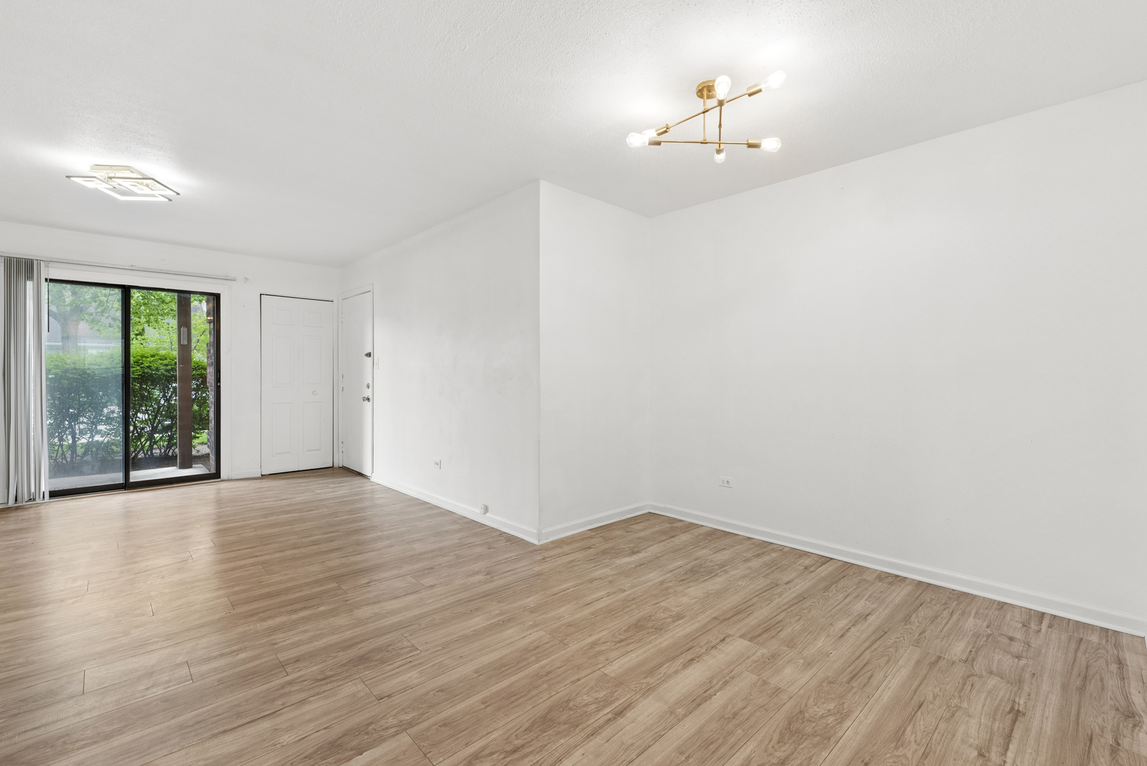 2213 West Nichols Road, Unit B Arlington Heights, IL 60004 - Photo 6 of 23 a view of a room with wooden floor and a ceiling fan