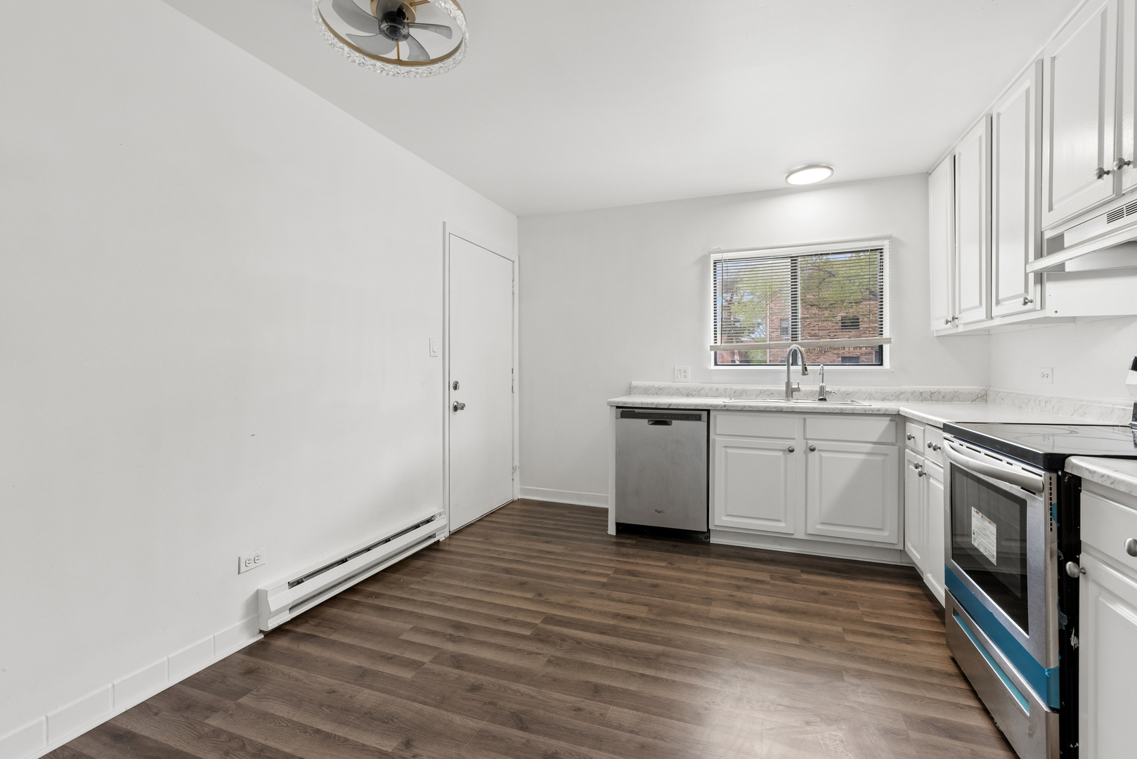 2213 West Nichols Road, Unit B Arlington Heights, IL 60004 - Photo 8 of 23 a kitchen with a sink cabinets stainless steel appliances and a window
