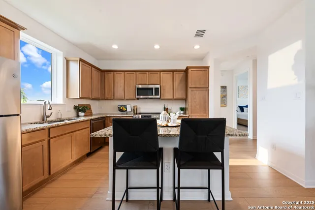 a kitchen with a dining table chairs and a refrigerator