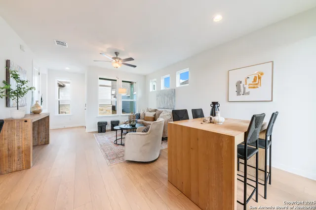 a living room with furniture a chandelier and a dining table