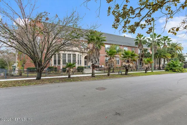a view of a house with a yard and palm trees