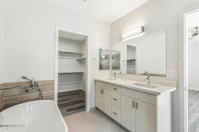 a bathroom with a tub sink and mirror