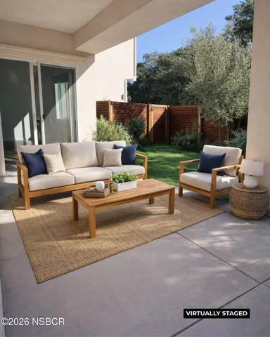 a view of a patio with couches and a table and chairs with wooden fence