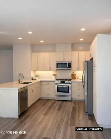 a kitchen with stainless steel appliances a refrigerator sink and stove