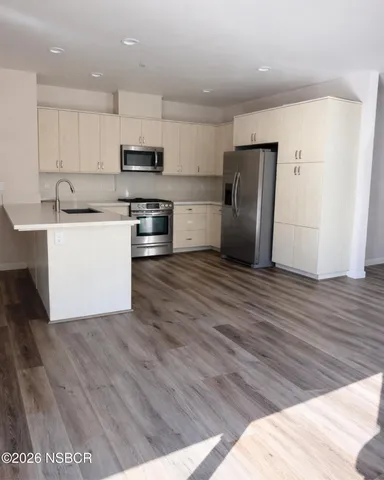 a kitchen with stainless steel appliances granite countertop a refrigerator sink and stove