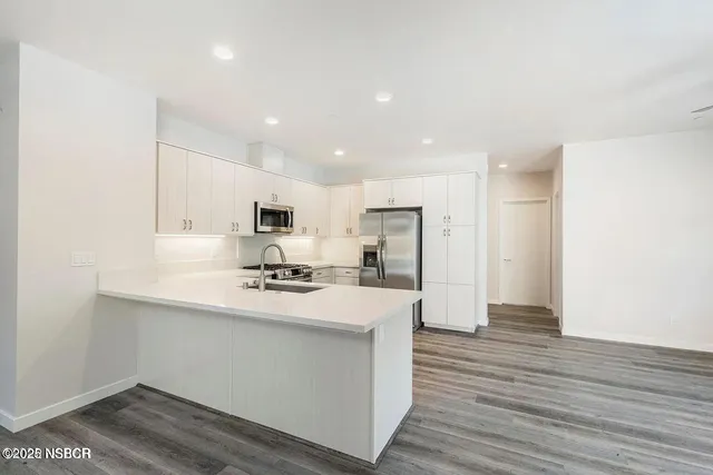 a kitchen with stainless steel appliances a refrigerator and a stove top oven