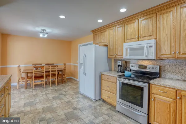 a kitchen with furniture a refrigerator and a stove top oven