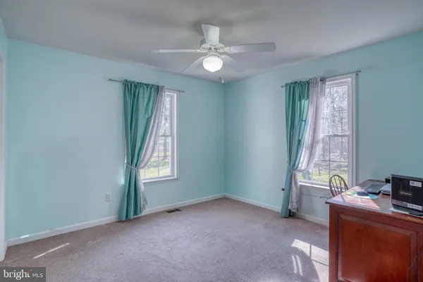 a view of an empty room with window and bathroom