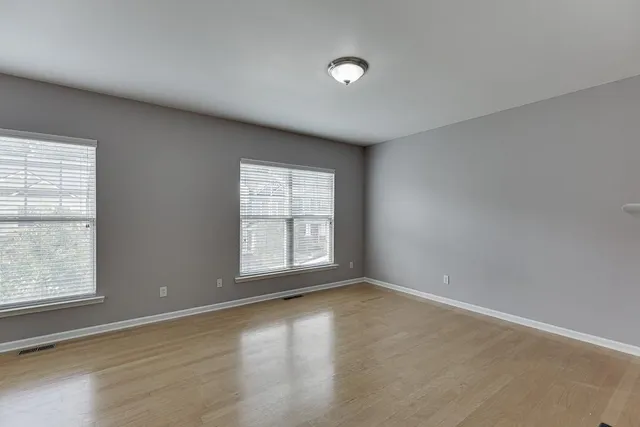 a view of empty room with fireplace and wooden floor
