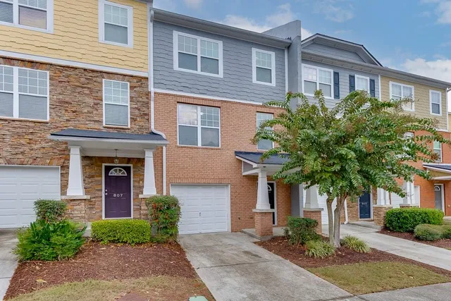 a front view of a house with yard and parking space