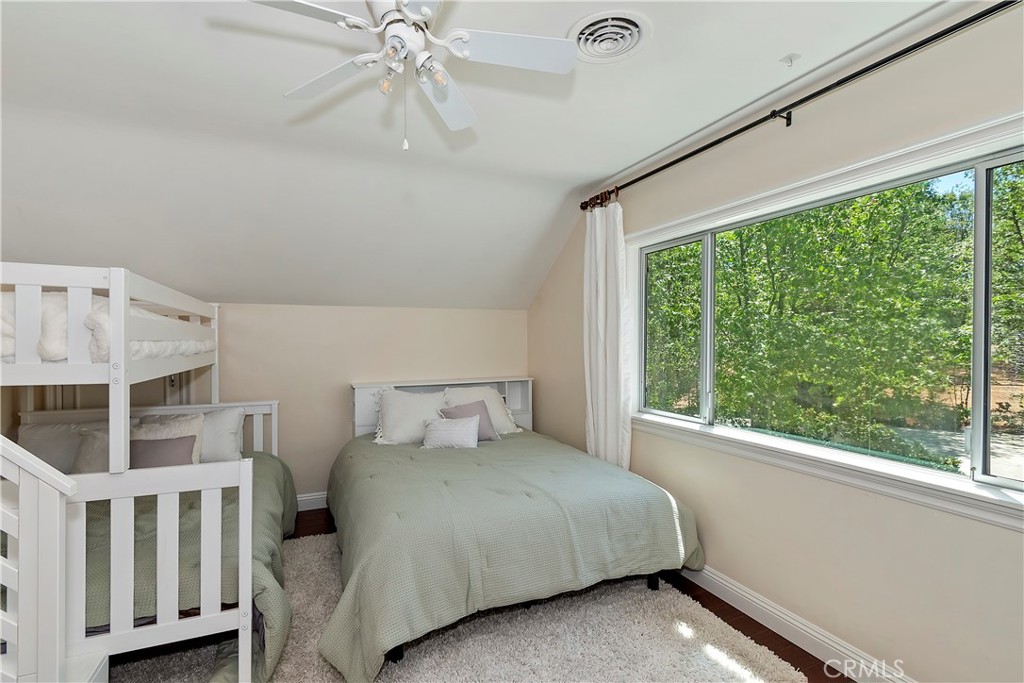 28411 North Shore Road Lake Arrowhead, CA 92352 - Photo 39 of 66 a bedroom with a large bed and a chandelier