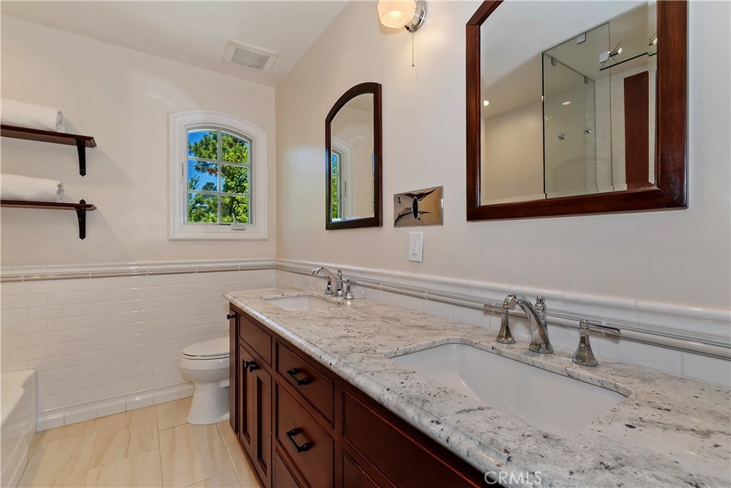 28411 North Shore Road Lake Arrowhead, CA 92352 - Photo 40 of 66 a bathroom with a granite countertop sink a toilet and a mirror