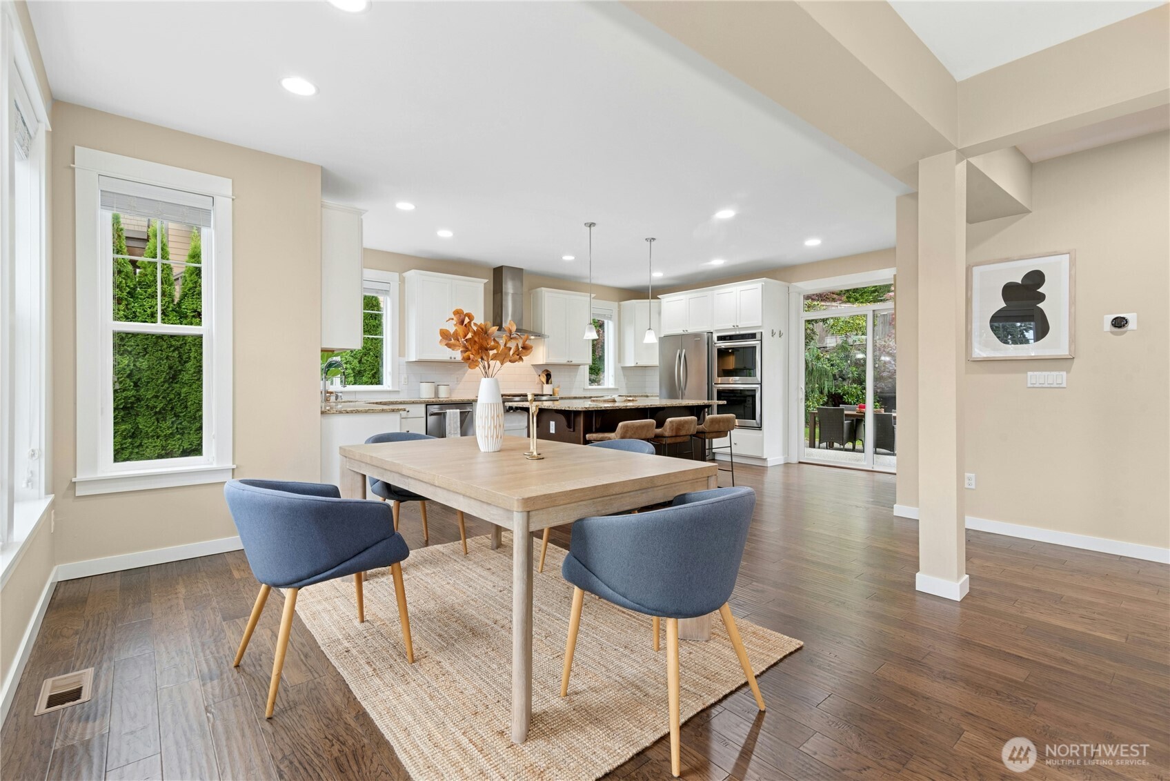 14713 98th Avenue Northeast Bothell, WA 98011 - Photo 8 of 40 a open dining room with kitchen island stainless steel appliances wooden floor dining table chairs and wooden floor