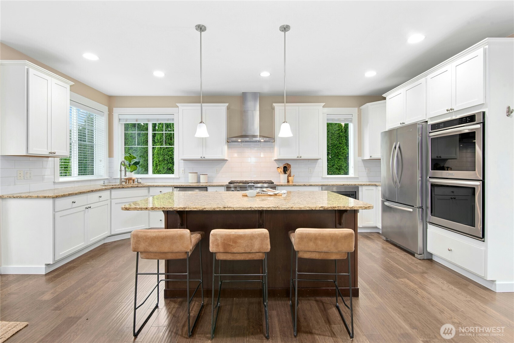 14713 98th Avenue Northeast Bothell, WA 98011 - Photo 9 of 40 a kitchen with stainless steel appliances granite countertop a stove a sink a microwave a refrigerator a dining table and chairs with wooden floor