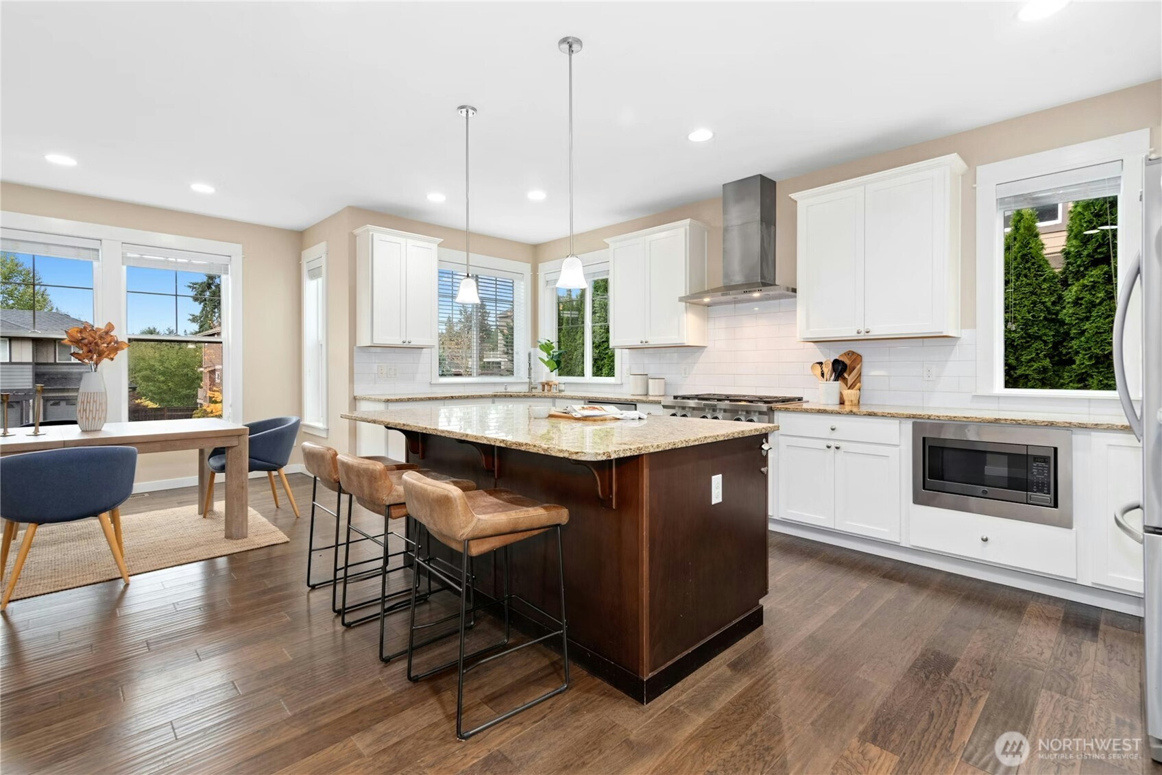 14713 98th Avenue Northeast Bothell, WA 98011 - Photo 10 of 40 a kitchen with a stove a sink a dining table and chairs