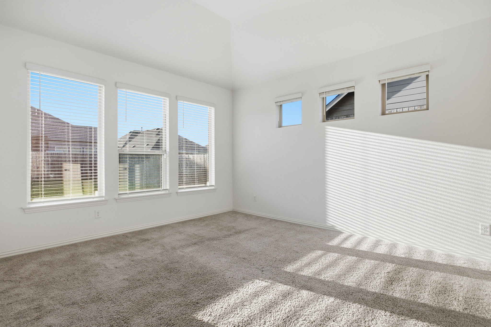 13720 Jon Ryan Road Manor, TX 78653 - Photo 15 of 31 A well-lit, neutral-toned room features high ceilings and multiple windows providing ample natural illumination.