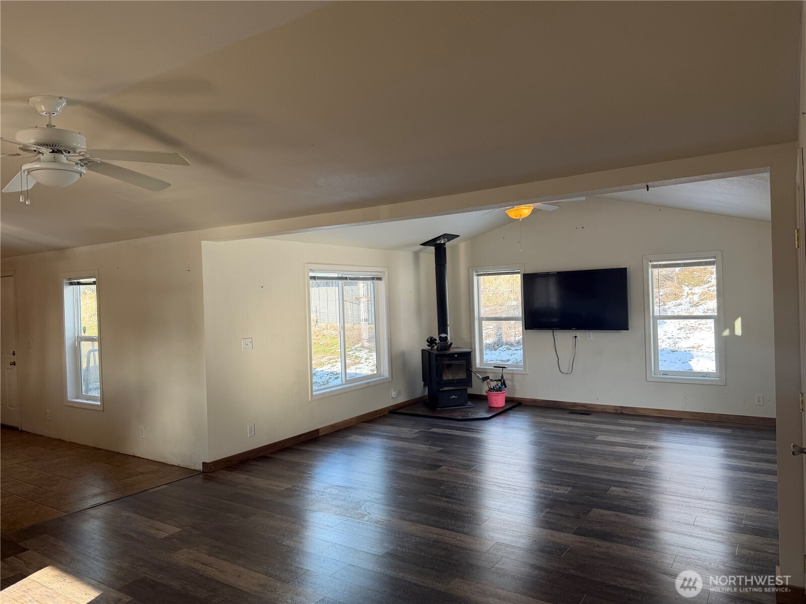 87 Canyon Creek Road Oroville, WA 98844 - Photo 3 of 24 an empty room with wooden floor and windows