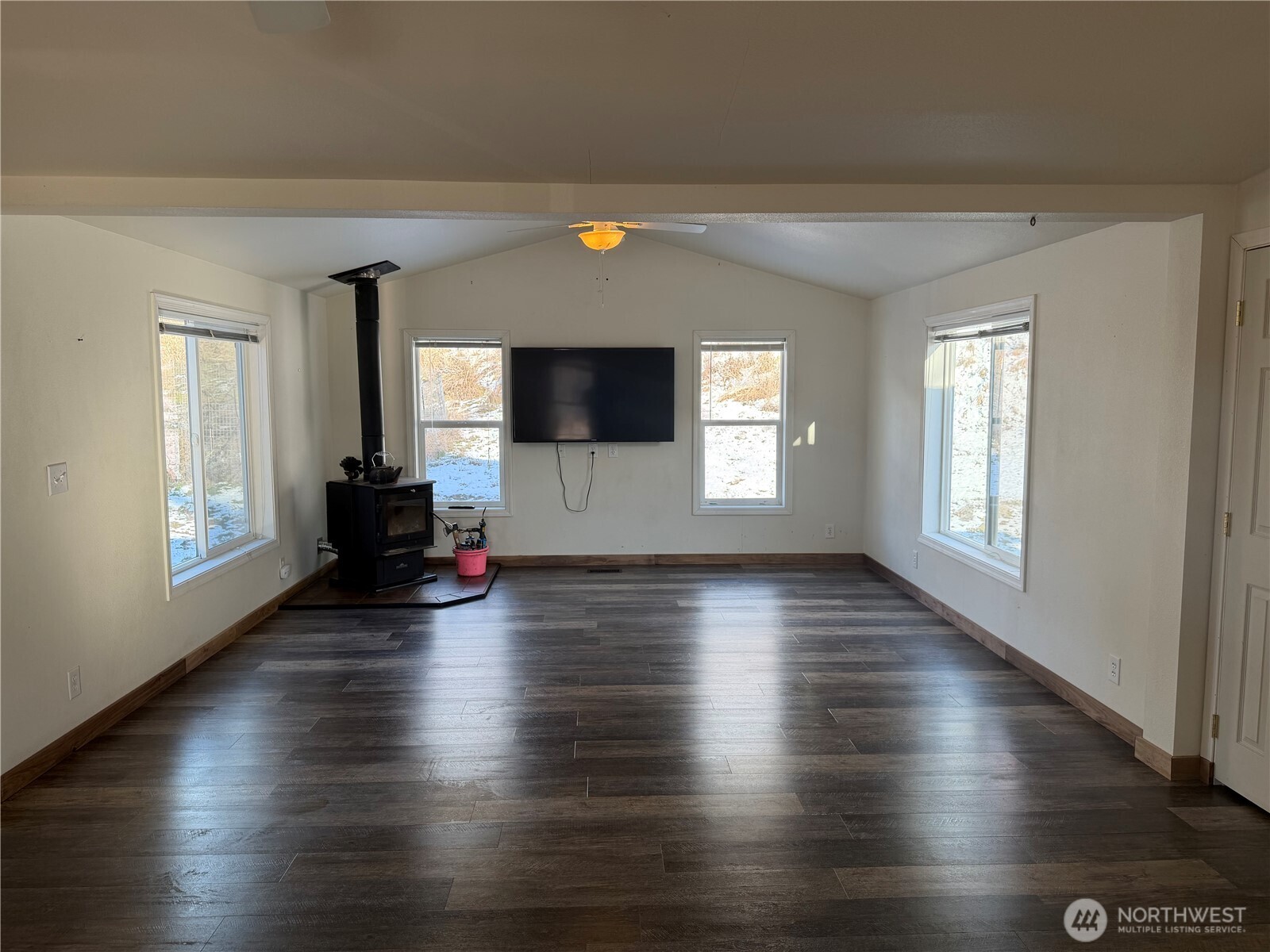 87 Canyon Creek Road Oroville, WA 98844 - Photo 4 of 24 an empty room with wooden floor and windows