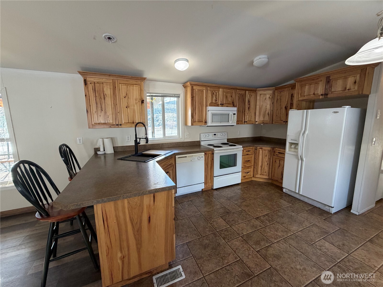 87 Canyon Creek Road Oroville, WA 98844 - Photo 6 of 24 a kitchen with stainless steel appliances granite countertop a sink a stove a refrigerator a microwave a counter top space and cabinets