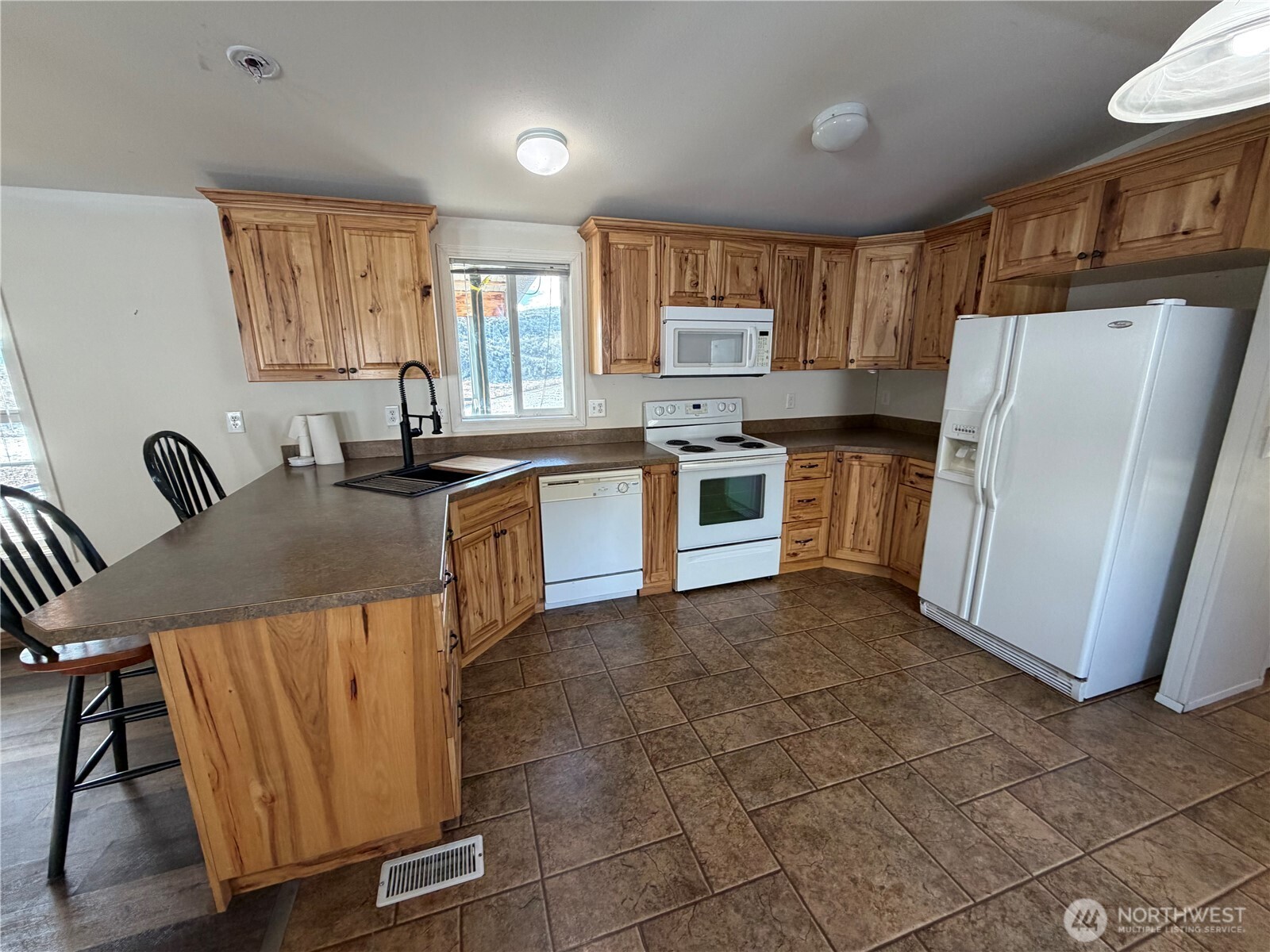 87 Canyon Creek Road Oroville, WA 98844 - Photo 7 of 24 a kitchen with granite countertop a refrigerator stove top oven and sink