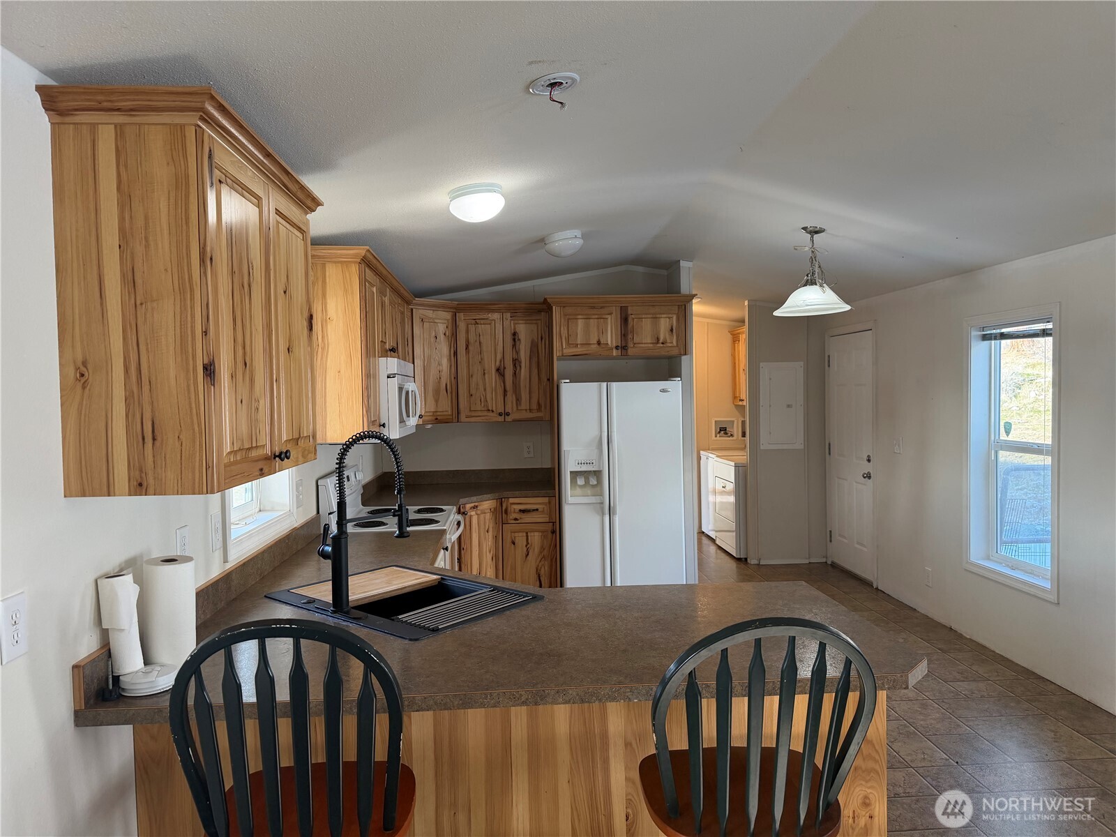 87 Canyon Creek Road Oroville, WA 98844 - Photo 9 of 24 a kitchen with sink refrigerator dining table and chairs