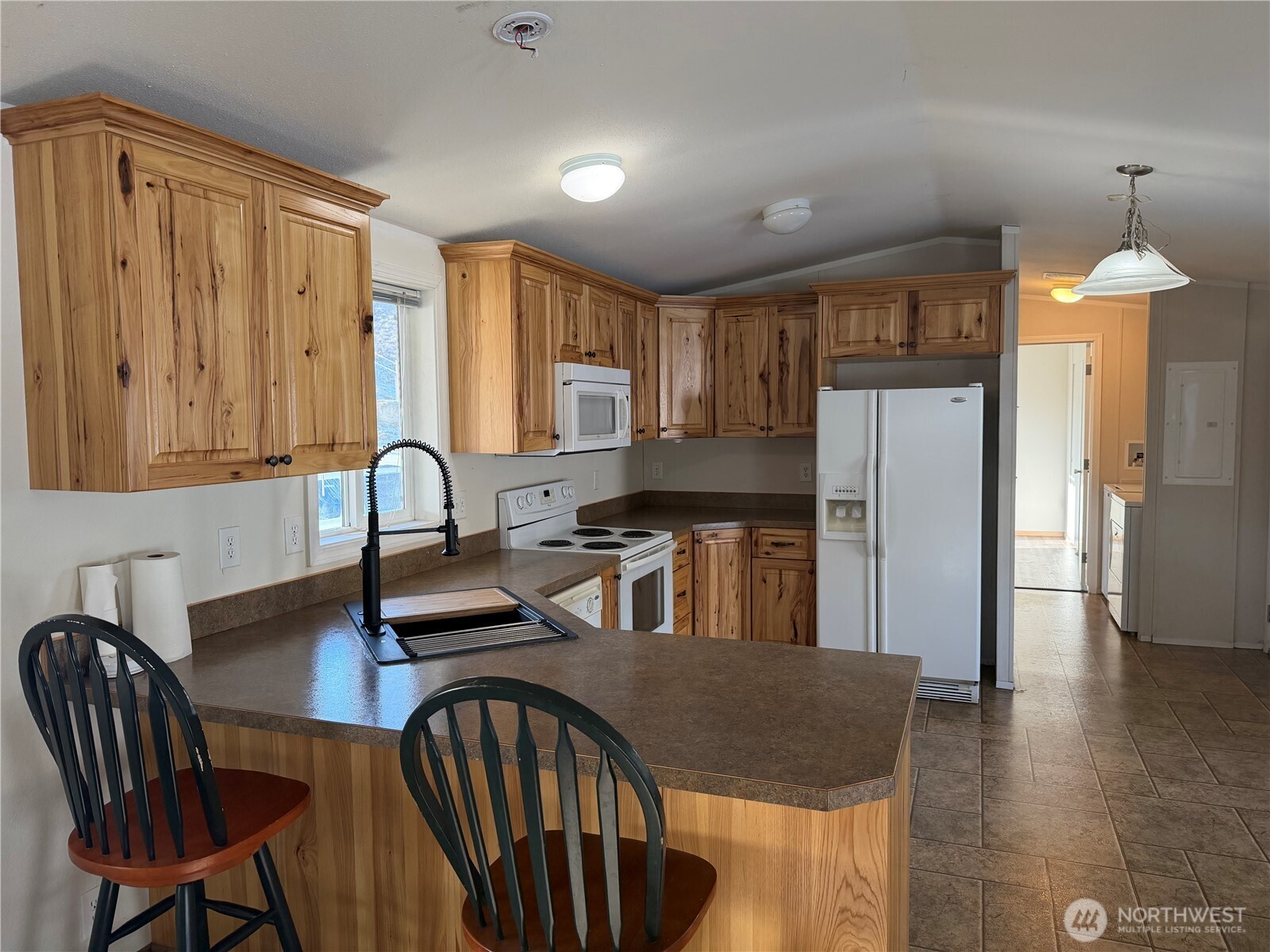 87 Canyon Creek Road Oroville, WA 98844 - Photo 10 of 24 a kitchen with granite countertop a refrigerator a stove a sink dishwasher with a dining table and chair