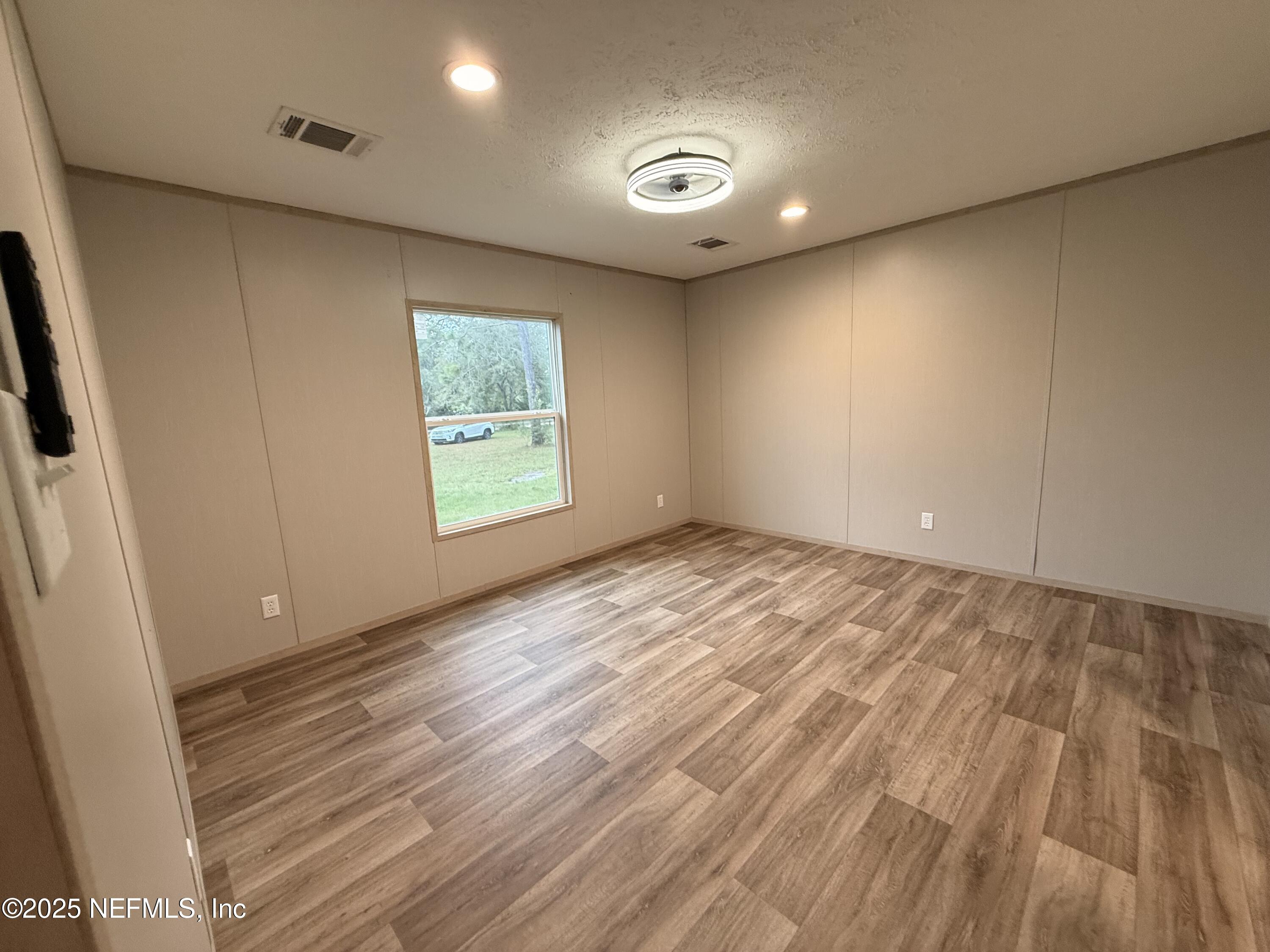 2355 Walters Road Middleburg, FL 32068 - Photo 12 of 63 an empty room with wooden floor and windows