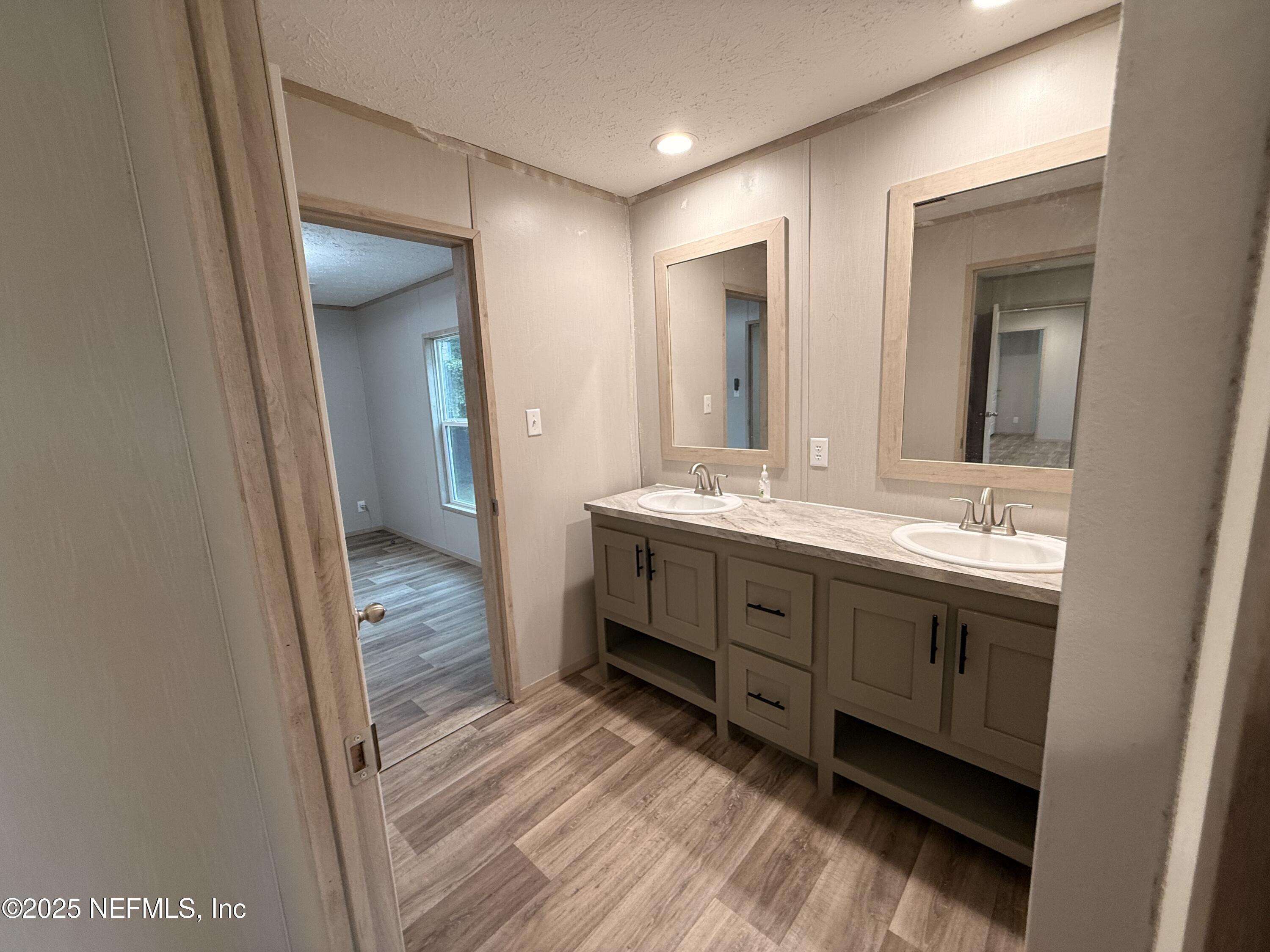 2355 Walters Road Middleburg, FL 32068 - Photo 21 of 63 a bathroom with a double vanity sink and mirror