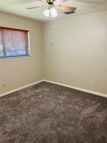 an empty room with a chandelier fan