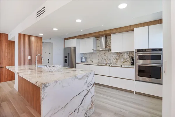 a kitchen with stainless steel appliances granite countertop a stove a sink and a refrigerator