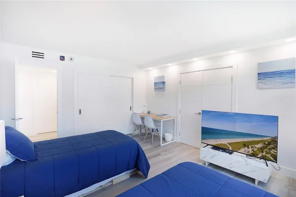 a bedroom with two large bed and a flat screen tv