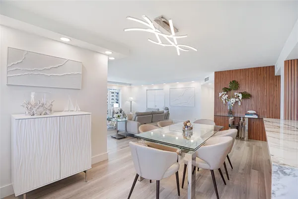 a dining room with furniture a chandelier and wooden floor