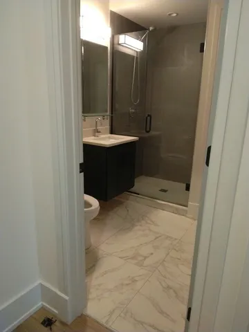 a bathroom with a sink a toilet and shower