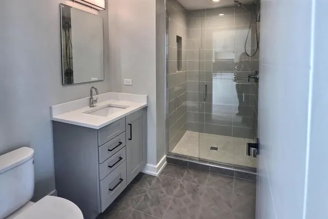 a bathroom with a sink a toilet and shower